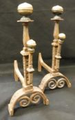 A pair of 18th Century Continental brass and iron fire dogs with brass turned finials on an iron