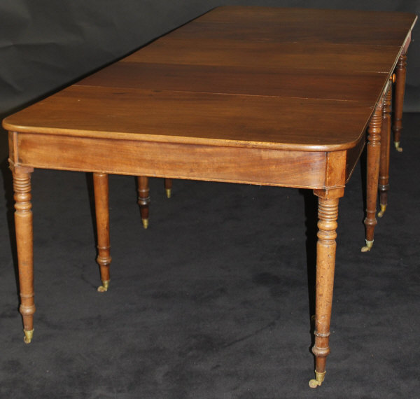 A Regency mahogany extending dining table, the rectangular end sections with rounded corners,