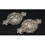 A matched pair of late Victorian silver twin-handled bonbon dishes with pierced and embossed