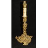 A 19th Century gilt brass candlestick in the Rococo taste with C scrolling foliate,