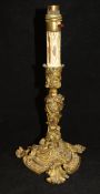 A 19th Century gilt brass candlestick in the Rococo taste with C scrolling foliate,