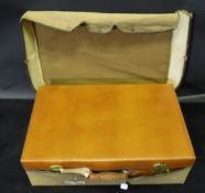 A leather suitcase with brass fittings, stamped to interior "Real Cowhide Made in England",