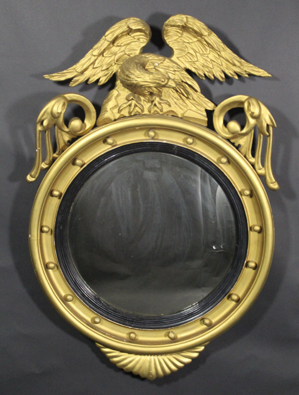 A 19th Century gilt framed convex circular wall mirror, the top surmounted by an eagle,