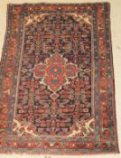A Caucasian rug, the central panel set with floral decorated medallion on a dark blue ground,