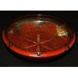 A Royal Lancastrian ruby red lustre bowl, the centre field decorated with flower head,