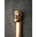 An Eastern hardwood walking cane, the handle formed as monkey head with ivory eyeballs,