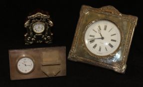 A modern silver-mounted mantle clock of shaped form, decorated with floral,
