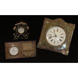 A modern silver-mounted mantle clock of shaped form, decorated with floral,