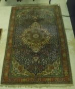 An Oriental carpet, the central panel set with a floral decorated medallion on a blue ground,