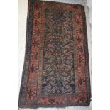 A Caucasian rug, the central panel set with repeating floral motifs on a brown ground,