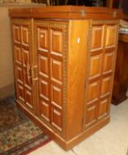 A modern hardwood drinks' cabinet with carved Indonesian style decoration,