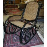 An ebonised framed bentwood rocking chair with cane seat and back by Thonet,