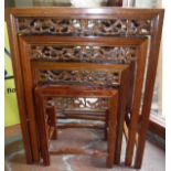 A modern Chinese quartetto nest of cherry wood occasional tables with carved decoration