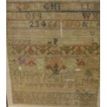 A 19th Century needlework sampler by Ann Smith featuring the alphabet, vase of flowers, numerals,
