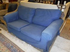 A modern two seat sofa with blue loose covers