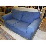 A modern two seat sofa with blue loose covers