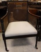 A 19th Century mahogany framed bergère library chair with caned back and arms and upholstered seat,