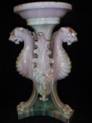 A Dunmore type pale sang de boeuf glazed jardinier stand decorated with gryphon monopodia on a