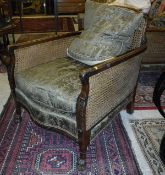 A pair of circa 1920 Bérgère chairs with acanthus leaf decoration to the arms and front legs,