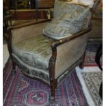 A pair of circa 1920 Bérgère chairs with acanthus leaf decoration to the arms and front legs,