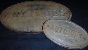 A reproduction painted cast iron "Antiques" sign and another similar smaller*