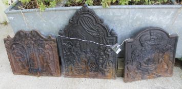 Three various cast iron fire backs, one depicting a pair of cavaliers underneath arches,