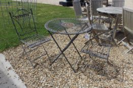A modern painted metal garden bistro table and chair set with scrolling decoration