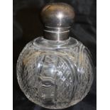 An Edwardian scent bottle with silver mounts and cut glass body,