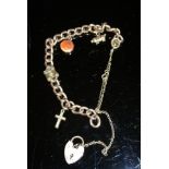 A 9 carat gold charm bracelet with heart shaped lock and various charms to include a pig and pair