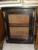 A Victorian ebonised and inlaid side cabinet with ormolu mounts raised on a plinth base with velvet