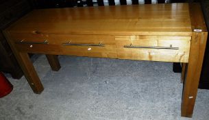 A modern oak three drawer side table on heavy square supports