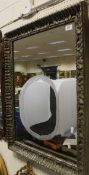 A rectangular wall mirror in a grey painted and moulded frame