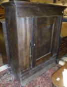 A 17th Century Dutch oak cabinet of plain form with single panelled door enclosing shelves with