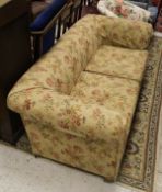 A circa 1900 upholstered Chesterfield type sofa, raised on bun feet with floral upholstery,