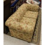 A circa 1900 upholstered Chesterfield type sofa, raised on bun feet with floral upholstery,