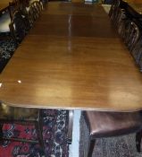 A mahogany D-end dining table in the Regency taste with twin end pillar supports terminating to
