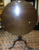 A 19th Century mahogany circular tilt-top tea table on turned and carved column to three acanthus