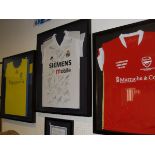 A collection of three framed and glazed football shirts including Arsenal Soccer School Costa Del