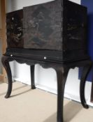 A Chinese lacquered and painted cabinet on stand, the top with engraved brass embellishments,