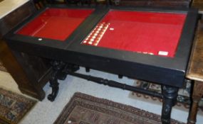 An ebonised bijouterie table in the Victorian manner with two glazed rising compartments on end