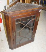 A 19th Century oak corner cabinet with astragal glazed doors opening to reveal three shaped shelves