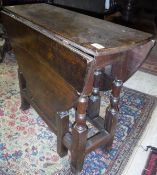 A late 18th/early 19th Century oak gate-leg drop-leaf dining table of oval form on turned supports