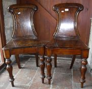 A pair of Victorian oak panel seated hall chairs on baluster turned front legs