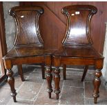 A pair of Victorian oak panel seated hall chairs on baluster turned front legs