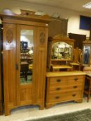 An early 20th Century satin walnut single door wardrobe with shaped pediment,