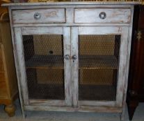 A Continental painted pine food cupboard of two drawers over two wired cupboard doors