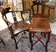 A pair of Chinese rosewood corner chairs with carved decoration of birds amongst prunus blossom in
