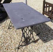 An early 20th Century cast iron painted Singer sewing machine table base with slate top