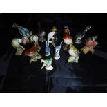 A collection of fifteen various china bird figures including Beswick "Greenfinch", "Kingfisher",