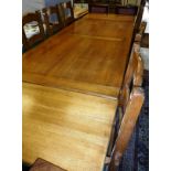 A modern oak farmhouse style kitchen table with two end leaves,